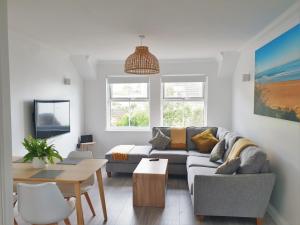 a living room with a couch and a table at Surfside in Woolacombe