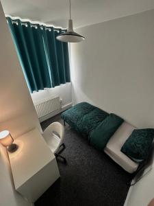 Cette petite chambre comprend un lit et une chaise. dans l'établissement Shoreditch Rooms R2, à Londres