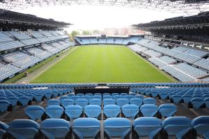a stadium with blue seats and a tennis court at Casa Navarro in Vigo