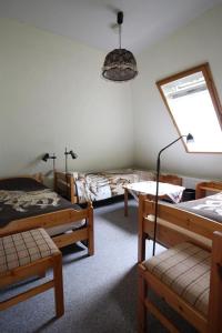 a bedroom with three beds and a table and a window at Tetenshof für Pferdeliebhaber in Westerhever