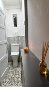 a bathroom with a toilet and a counter with candles at Shoreditch Rooms R2 in London