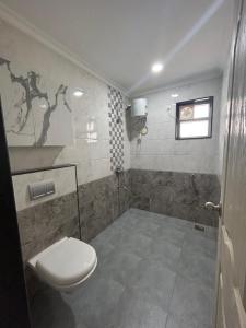 a bathroom with a toilet and a window at HOLIDAY LUXURY APARTMENT in Arpora