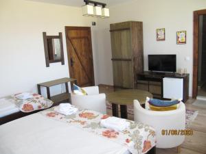 sala de estar con mesa, sillas y TV en Guest House Belchin View, en Belchin