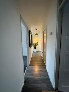 a hallway with white walls and wooden floors and doors at Shoreditch Rooms R2 in London