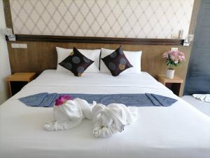 a bedroom with a white bed with towels on it at NJ PATONG HOTEL in Patong Beach