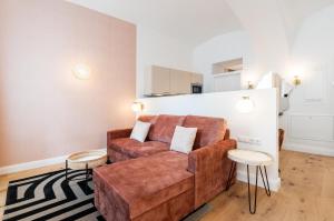 uma sala de estar com um sofá castanho e duas mesas em easy flat Sankt Elisabeth em Viena