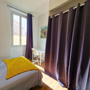 a bedroom with purple curtains and a window with a desk at Le Central Parc - T2-Spacieux-Clim-Wifi in Marseille