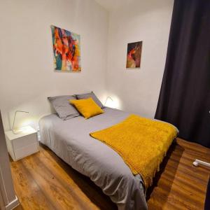 a bedroom with a bed with a yellow blanket at Le Central Parc - T2-Spacieux-Clim-Wifi in Marseille