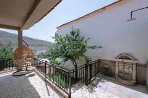 a balcony of a house with a tree and a fan at OAZA Thasos in Prinos