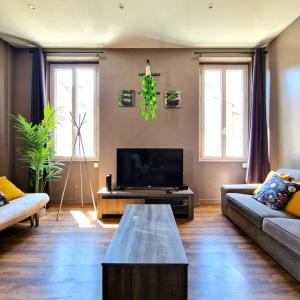 a living room with a couch and a tv at Le Central Parc - T2-Spacieux-Clim-Wifi in Marseille