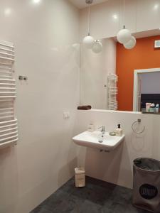 a bathroom with a white sink and an orange wall at Slaska 12 in Gdańsk
