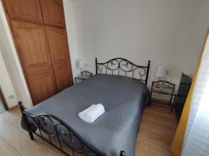 ein Schlafzimmer mit einem schwarzen Bett und einem Handtuch darauf in der Unterkunft Le Haut-Val Résidences in Bellême