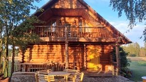 a log cabin with a table and chairs in front of it at Brīvdienu māja Pie sievasmātes in Cesvaine