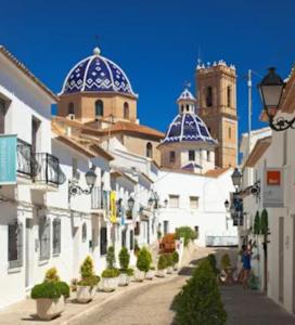 una calle con edificios blancos con cúpulas azules en Altea Playa Roda, en Altea