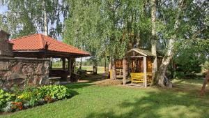 un jardin avec un kiosque et un arbre dans l'établissement Brīvdienu māja Pie sievasmātes, à Cesvaine