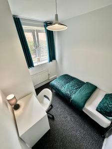 Cette petite chambre comprend un lit et un bureau. dans l'établissement Shoreditch Rooms R2, à Londres