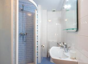 a white bathroom with a sink and a shower at Altea Playa Roda in Altea