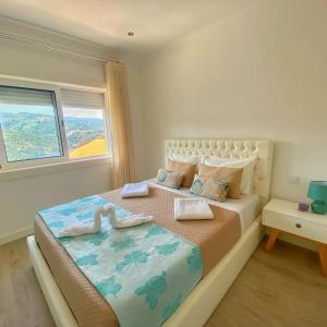 a bedroom with a large bed and a window at Refúgio Douro abelhal in Santa Cruz do Douro