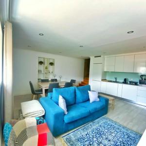 ein Wohnzimmer mit einer blauen Couch und einer Küche in der Unterkunft Varanda Do Abelhal in Santa Cruz do Douro