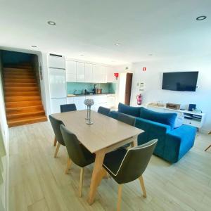 a living room with a table and a blue couch at Refúgio Douro abelhal in Santa Cruz do Douro