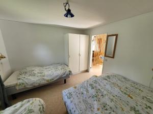 a bedroom with two beds and a closet at Stugby Marieke - Skärvången in Föllinge