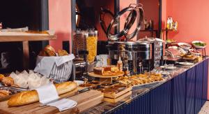a breakfast buffet with bread and pastries on a counter at Heritage Hotel and Suites in Tbilisi City