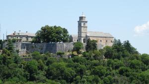 Casa vacanze - alloggio agrituristico Col في Monrupino: قلعة قديمة على قمة تل به أشجار