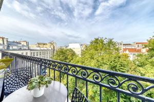 uma varanda com mesa e cadeiras e vista para a cidade em Stunning Apartment 2br + balcony + nice view em Paris