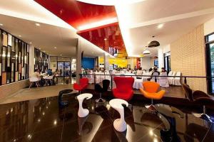 孔敬的住宿－I Hotel Khonkaen，餐厅设有红色和橙色的椅子和桌子