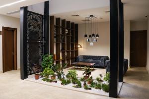 EPIGRAPH Design Hotel في تبليسي: غرفة معيشة بها أريكة وبعض النباتات