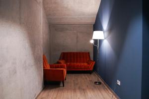 a living room with a red couch and a lamp at EPIGRAPH Design Hotel in Tbilisi City