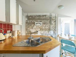 een keuken met een wastafel en een stenen muur bij The Coach House - Unique split level property in Kent +22 foto's