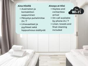 een witte kamer met 2 bedden en een muur met woorden bij Hiisi Homes Helsinki Sörnäinen in Helsinki