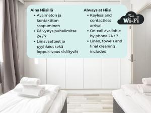 a white room with two beds and a wall with words at Hiisi Homes Helsinki Sörnäinen in Helsinki