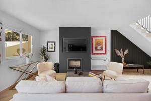 a living room with white furniture and a fireplace at Lotta's Townhouse Atalaya in Estepona