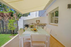 a kitchen and dining room with a white table and chairs at Lotta's Townhouse Atalaya in Estepona
