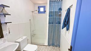 y baño con ducha, aseo y lavamanos. en Villa Mi Olvido V.V., en Sardina
