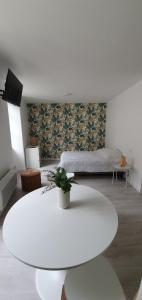 ein Wohnzimmer mit einem weißen Tisch und einem Bett in der Unterkunft Agréable studio in Bourgueil