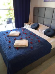 a bed with red roses and towels on it at Sea Power Residence Jastrzębia Góra in Jastrzębia Góra