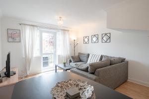 a living room with a couch and a table at Bright and modern 4-bed townhouse with garden near town centre in Kent
