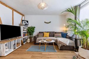 ein Wohnzimmer mit einem Sofa und einem TV in der Unterkunft La 12 in Bad Urach