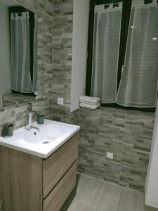een badkamer met een wastafel en een spiegel bij Maison Chez Laurent in Figari