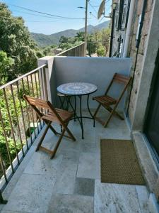 un patio con 2 sillas y una mesa en el balcón en Maison Chez Laurent, en Figari