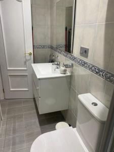 a white bathroom with a toilet and a sink at Estudio Bajamar in Torre del Mar +7 photos