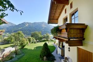 une maison avec un balcon donnant sur les montagnes en arrière-plan. dans l'établissement Ferienwohnung Widauer, à Brixen im Thale