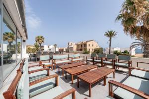 a row of wooden tables and chairs on a balcony at Villa Mar in Can Picafort
