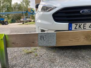 een witte auto geparkeerd naast een houten hek bij Jane’s place in Stockholm