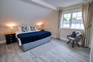 um quarto com uma cama, uma cadeira e uma janela em 9 Parklands Holiday home em Killarney