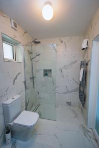 a white bathroom with a toilet and a shower at 9 Parklands Holiday home in Killarney