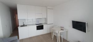 a kitchen with white cabinets and a small table at Apartamentos Horizonte in Playa del Ingles